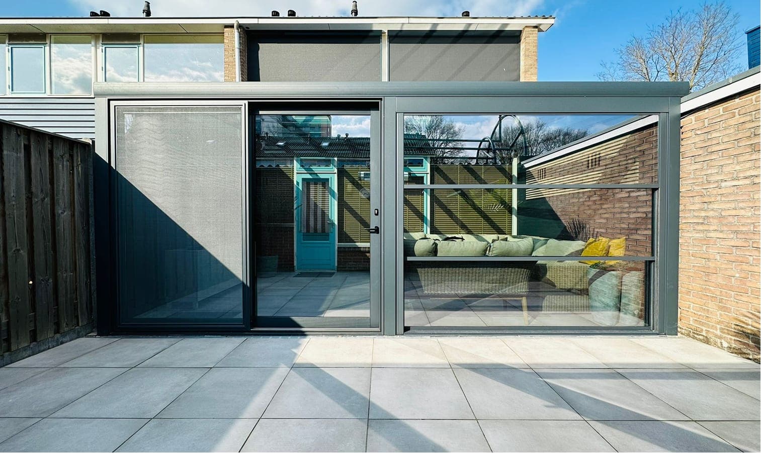 Aluminium veranda met glazen schuifwanden aan een moderne woning