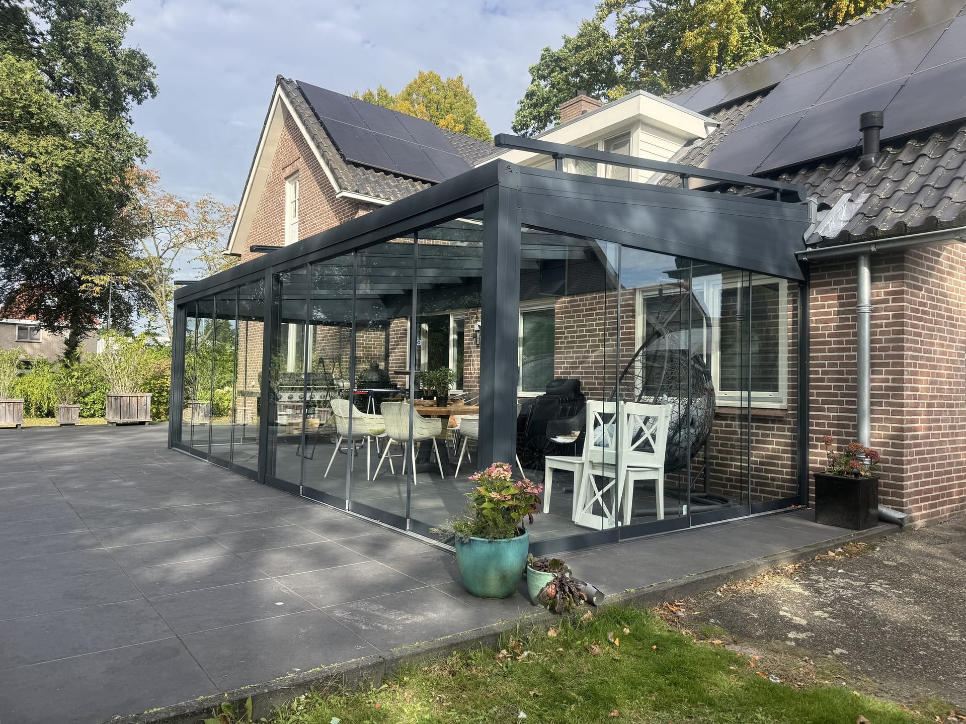 Tuinkamer met glazen dak in Almelo, schuin vanuit de tuin met terras op de voorgrond